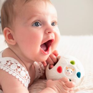 Un bébé avec la Balle sensorielle et de dentition - Sophie la Girafe dans les mains